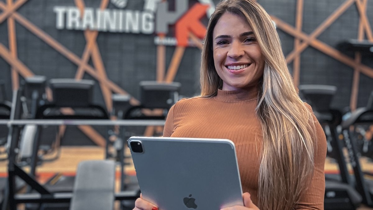 Nathalia Prado com tablet em academia